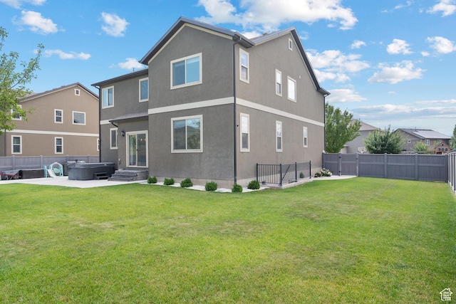 8791 N Suffolk Ln, Eagle Mountain, UT 84005 - back of house with a hot tub, stucco siding, a fenced backyard, and a patio