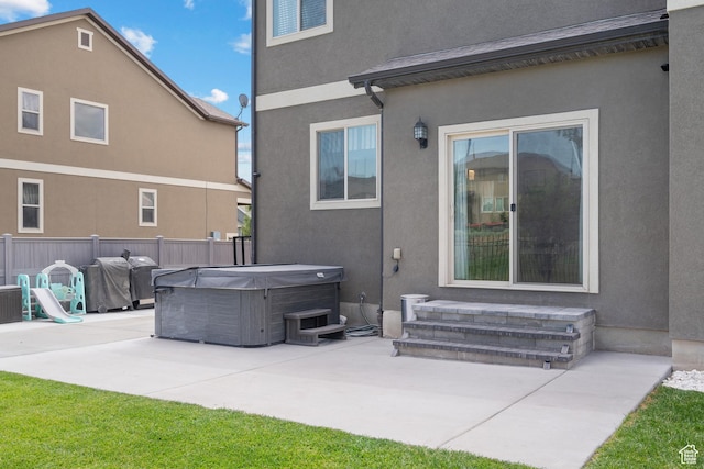 8791 N Suffolk Ln, Eagle Mountain, UT 84005 - back of property featuring a hot tub, a patio, and stucco siding