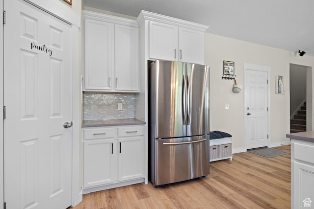 8791 N Suffolk Ln, Eagle Mountain, UT 84005 - kitchen featuring freestanding refrigerator, light wood-type flooring, backsplash, and white cabinets