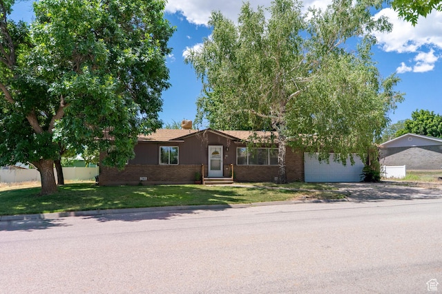 481 W Oak Crest Dr, Monticello, UT 84535 - view of front of house with brick siding, concrete driveway, entry steps, an attached garage, and a chimney