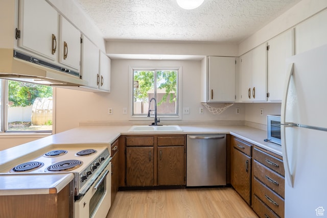 481 W Oak Crest Dr, Monticello, UT 84535 - kitchen featuring white appliances, under cabinet range hood, light countertops, a textured ceiling, and light wood finished floors