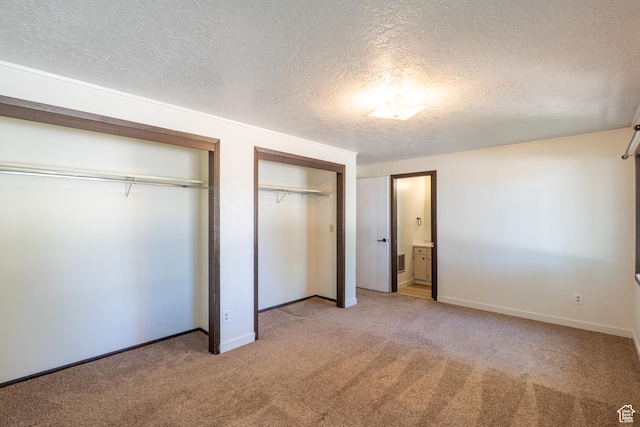 481 W Oak Crest Dr, Monticello, UT 84535 - unfurnished bedroom featuring two closets, light carpet, and a textured ceiling