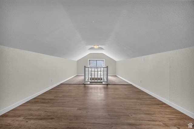 554 17th St, Ogden, UT 84404 - bonus room featuring vaulted ceiling, dark wood finished floors, a textured wall, and a textured ceiling
