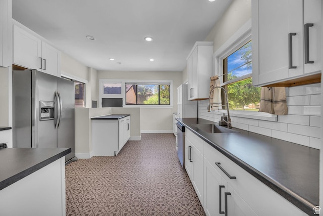 554 17th St, Ogden, UT 84404 - kitchen with appliances with stainless steel finishes, dark countertops, backsplash, recessed lighting, and white cabinets