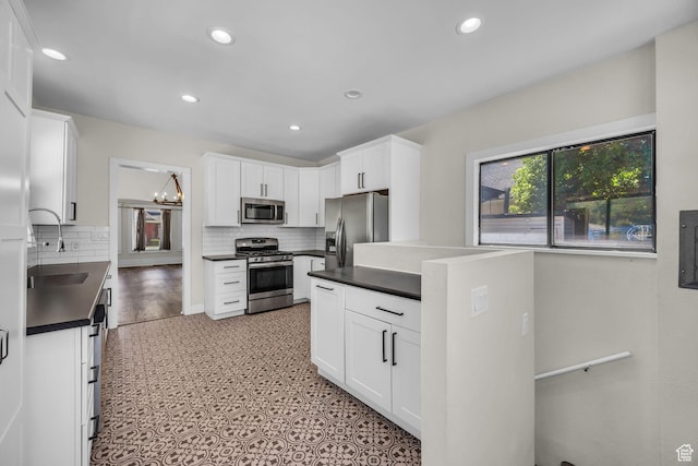 554 17th St, Ogden, UT 84404 - kitchen with appliances with stainless steel finishes, dark countertops, decorative backsplash, white cabinetry, and recessed lighting