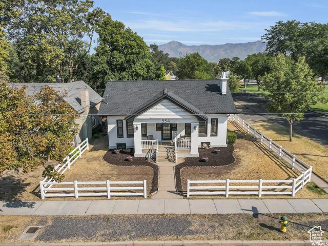554 17th St, Ogden, UT 84404 - bungalow-style house featuring a fenced front yard, covered porch, and a mountain view