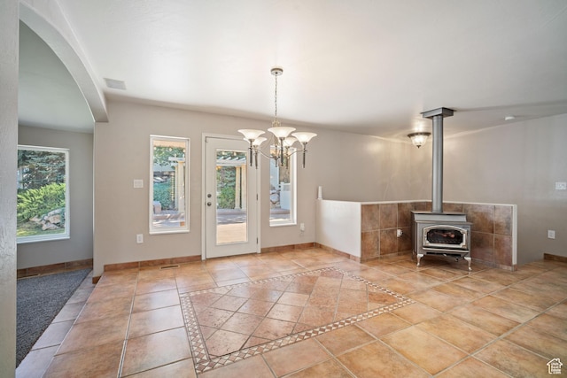 967 E Eaglewood Dr, North Salt Lake, UT 84054 - unfurnished living room featuring inlaid floor details, arched walkways, a chandelier, and a wood stove