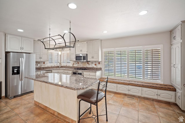 967 E Eaglewood Dr, North Salt Lake, UT 84054 - kitchen featuring appliances with stainless steel finishes, light stone countertops, tasteful backsplash, white cabinetry, and recessed lighting
