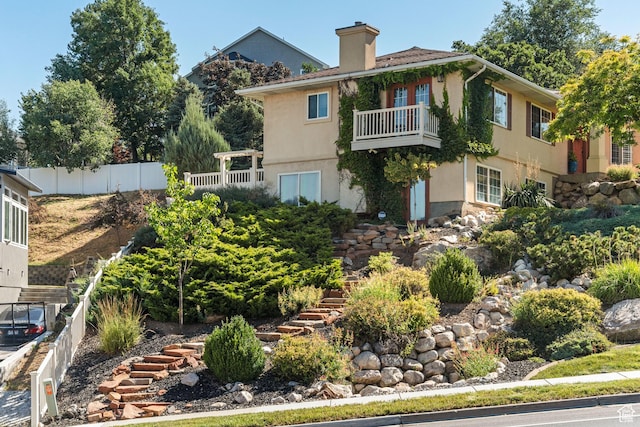 967 E Eaglewood Dr, North Salt Lake, UT 84054 - rear view of property featuring a balcony, a chimney, and stucco siding