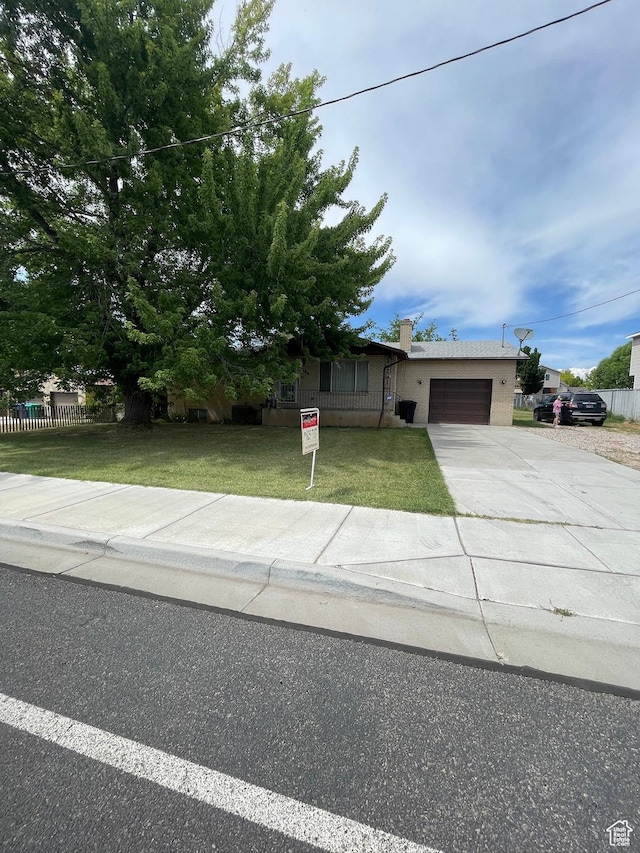 1692 W 300 N, West Point, UT 84015 - obstructed view of property with a garage, driveway, and a front lawn