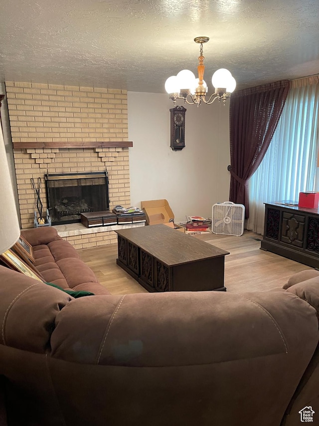 1692 W 300 N, West Point, UT 84015 - living room with a chandelier, a textured ceiling, wood finished floors, and a brick fireplace