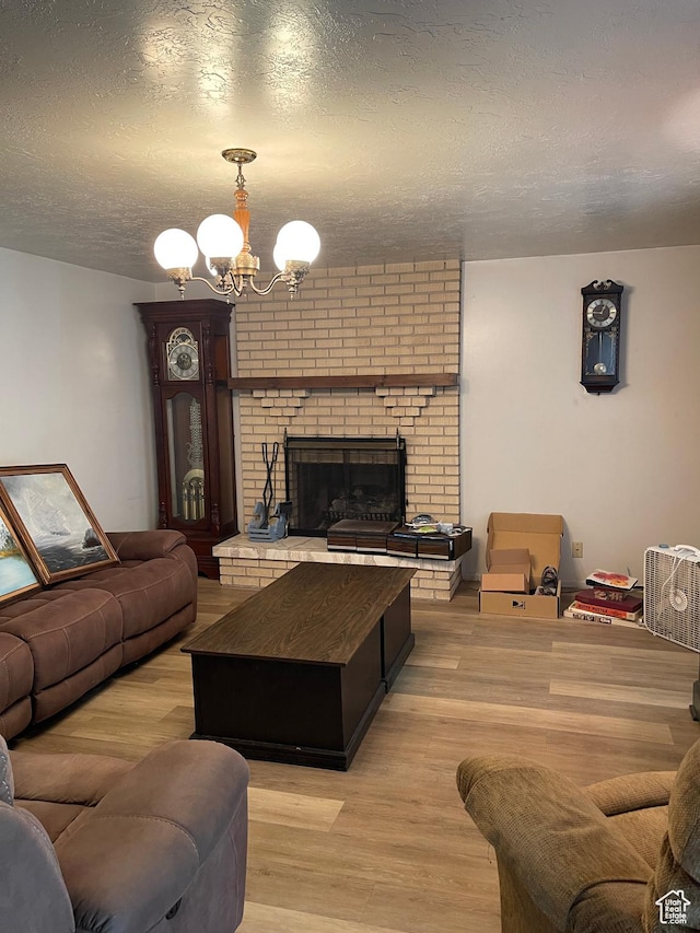 1692 W 300 N, West Point, UT 84015 - living area with a chandelier, light wood finished floors, a textured ceiling, and a brick fireplace