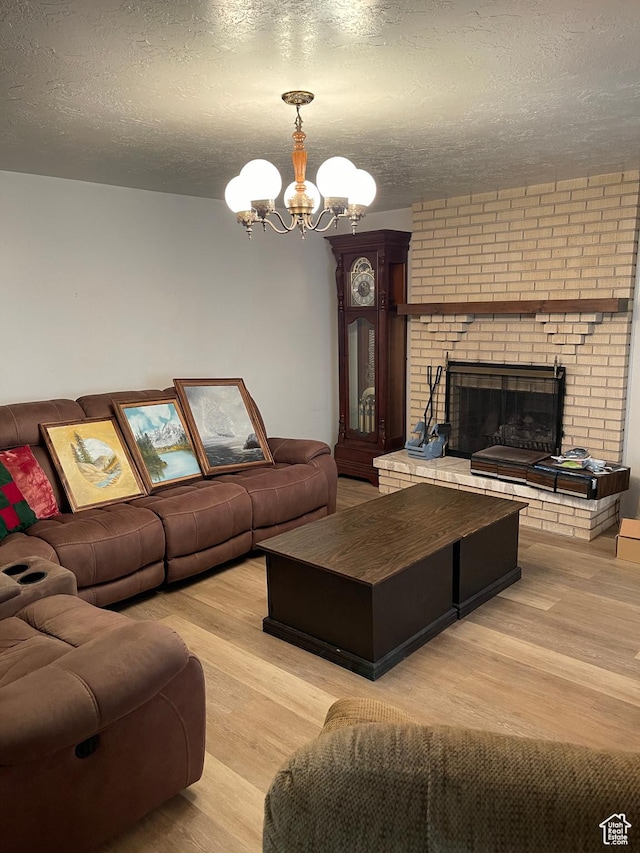 1692 W 300 N, West Point, UT 84015 - living room with light wood finished floors, a chandelier, a fireplace, and a textured ceiling