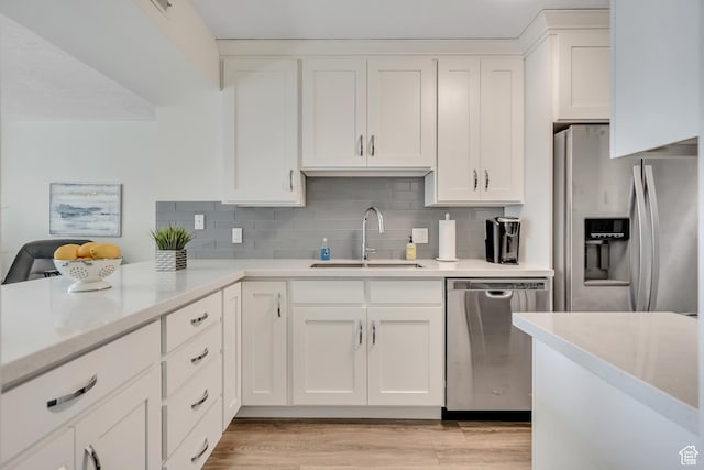 230 E Broadway Unit 401, Salt Lake City, UT 84111 - kitchen featuring appliances with stainless steel finishes, light countertops, white cabinetry, decorative backsplash, and light wood finished floors