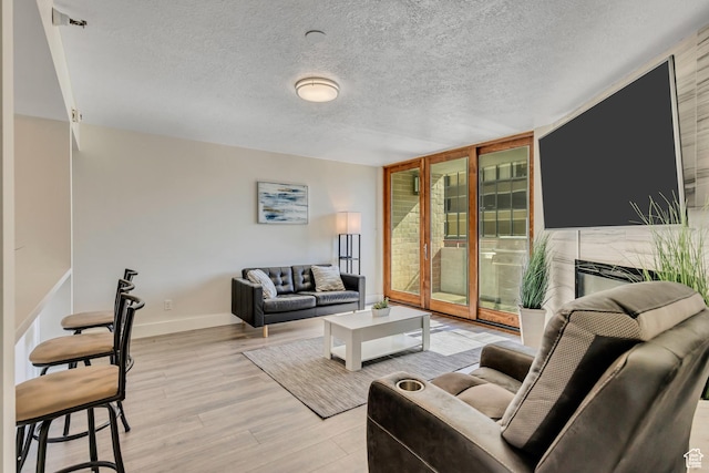 230 E Broadway Unit 401, Salt Lake City, UT 84111 - living area featuring floor to ceiling windows, light wood-style flooring, and a textured ceiling