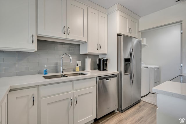 230 E Broadway Unit 401, Salt Lake City, UT 84111 - kitchen featuring appliances with stainless steel finishes, washer and clothes dryer, tasteful backsplash, and white cabinets