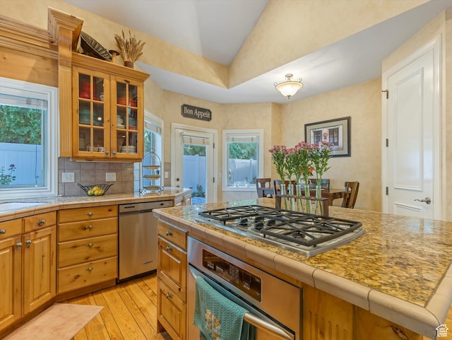 1832 E Cottonwood Glen Ct, Salt Lake City, UT 84117 - kitchen with stainless steel appliances, lofted ceiling, light wood-type flooring, healthy amount of natural light, and glass insert cabinets