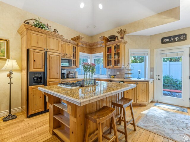1832 E Cottonwood Glen Ct, Salt Lake City, UT 84117 - kitchen featuring a center island, light wood-style flooring, paneled fridge, glass insert cabinets, and tasteful backsplash