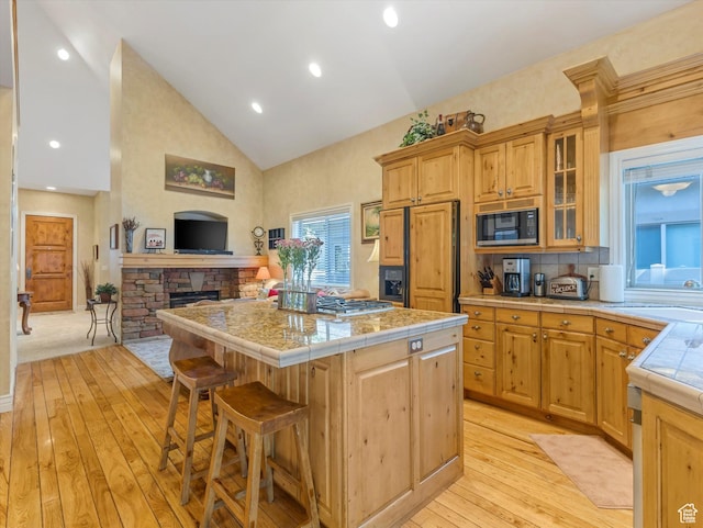 1832 E Cottonwood Glen Ct, Salt Lake City, UT 84117 - kitchen featuring paneled refrigerator, black microwave, a kitchen island, light wood-style flooring, and high vaulted ceiling