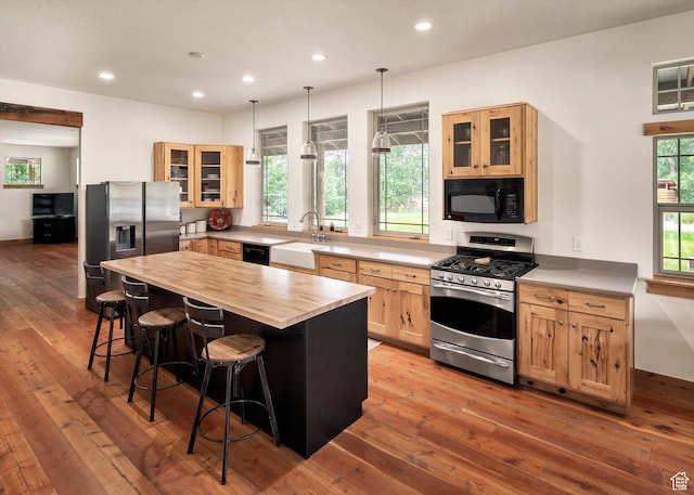 8817 E Mountain Valley Dr S, Huntsville, UT 84317 - kitchen with stainless steel appliances, light brown cabinets, a breakfast bar area, wooden counters, and wood-type flooring
