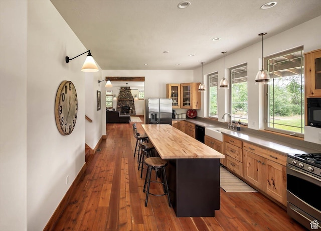 8817 E Mountain Valley Dr S, Huntsville, UT 84317 - kitchen featuring stainless steel appliances, wood counters, a kitchen bar, glass insert cabinets, and a kitchen island