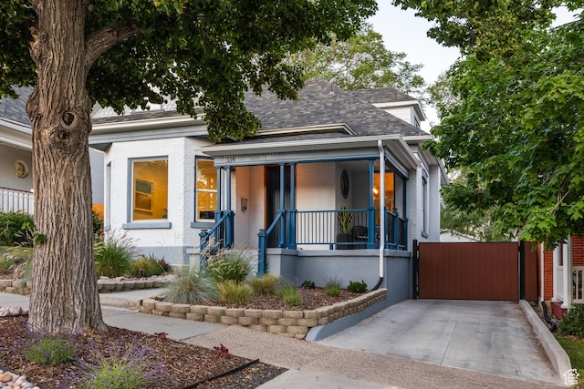 334 N C St, Salt Lake City, UT 84103 - view of front of property with brick siding, covered porch, and roof with shingles