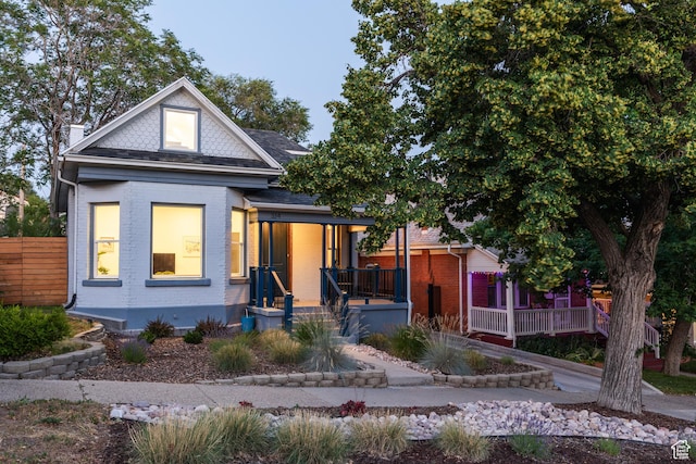 334 N C St, Salt Lake City, UT 84103 - view of front facade with a porch, brick siding, and a chimney