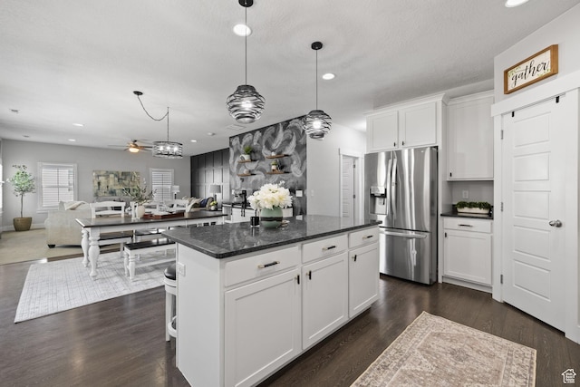 6523 W Bridge Maple Ln S, West Jordan, UT 84081 - kitchen with stainless steel fridge, a center island, a ceiling fan, open floor plan, and white cabinets