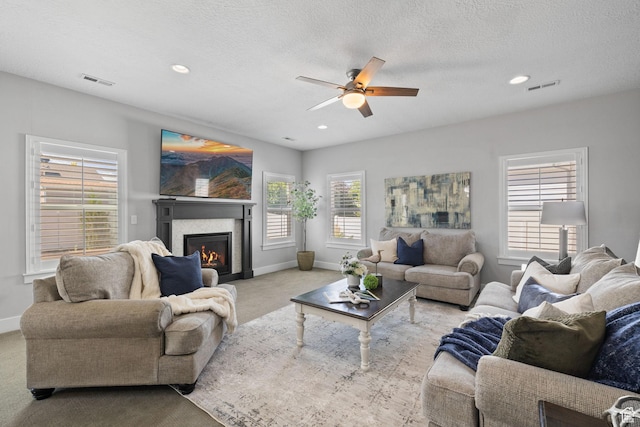 6523 W Bridge Maple Ln S, West Jordan, UT 84081 - carpeted living area with a glass covered fireplace, a ceiling fan, healthy amount of natural light, recessed lighting, and a textured ceiling