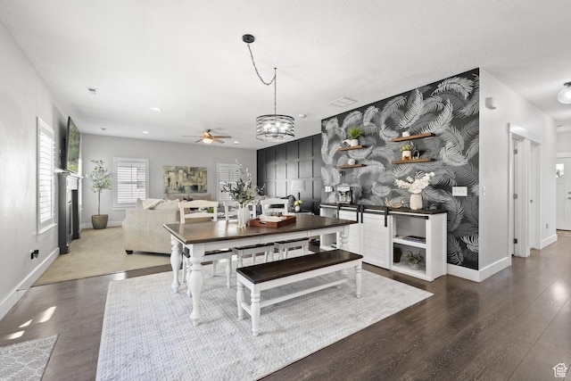 6523 W Bridge Maple Ln S, West Jordan, UT 84081 - dining space featuring a ceiling fan, wood finished floors, a chandelier, and a fireplace