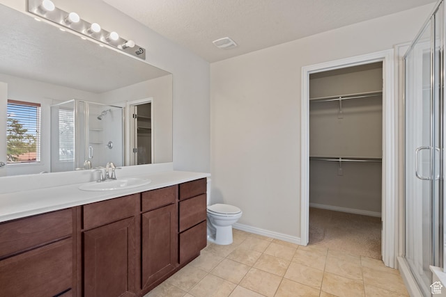 2794 W Harker Ridge Cv, Salt Lake City, UT 84129 - full bath featuring a walk in closet, a stall shower, vanity, and tile patterned flooring