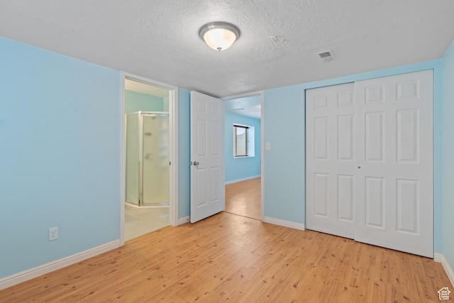 2794 W Harker Ridge Cv, Salt Lake City, UT 84129 - unfurnished bedroom with light wood-style flooring, a textured ceiling, a closet, and ensuite bath