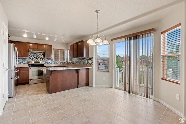 2794 W Harker Ridge Cv, Salt Lake City, UT 84129 - kitchen featuring appliances with stainless steel finishes, under cabinet range hood, light tile patterned flooring, decorative backsplash, and a textured ceiling