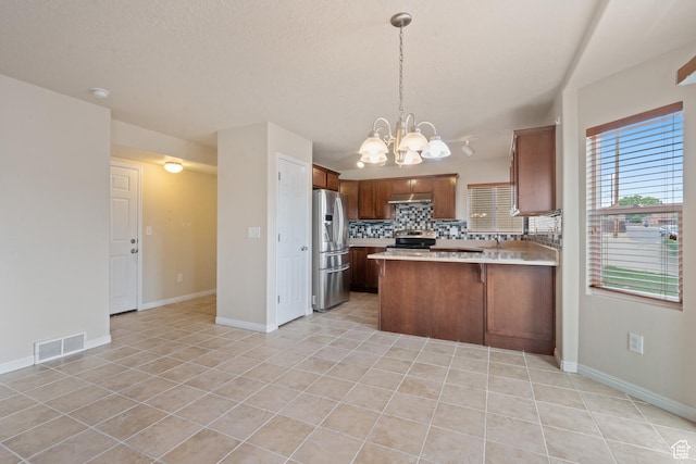 2794 W Harker Ridge Cv, Salt Lake City, UT 84129 - kitchen with stainless steel appliances, light tile patterned floors, light countertops, a chandelier, and tasteful backsplash