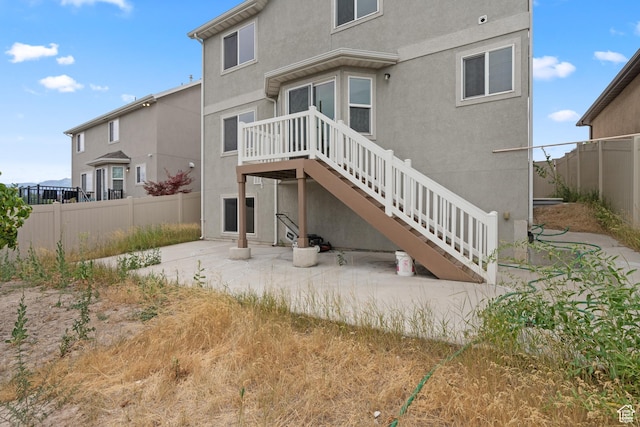 2794 W Harker Ridge Cv, Salt Lake City, UT 84129 - rear view of property featuring a patio, stucco siding, and stairway