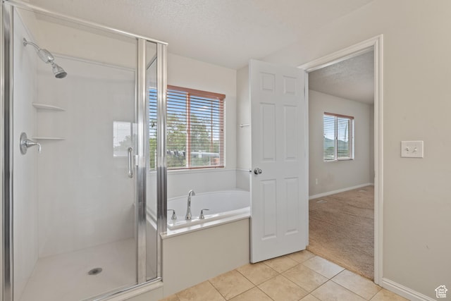2794 W Harker Ridge Cv, Salt Lake City, UT 84129 - full bath with a textured ceiling, tile patterned flooring, a shower stall, and a bath