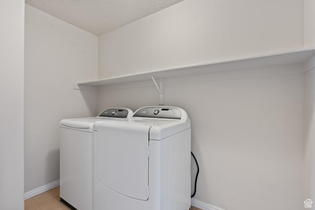 2794 W Harker Ridge Cv, Salt Lake City, UT 84129 - washroom with washing machine and clothes dryer, a textured ceiling, and light tile patterned flooring