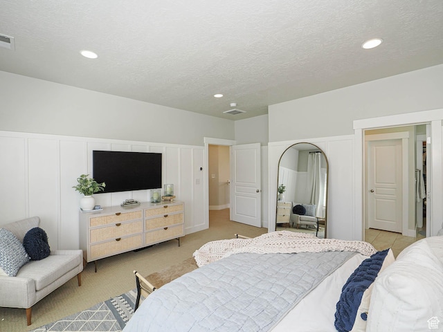 618 E Beaumont Way S, Draper, UT 84020 - bedroom with a textured ceiling, a decorative wall, recessed lighting, light carpet, and arched walkways