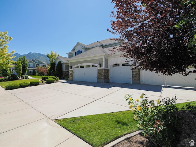 618 E Beaumont Way S, Draper, UT 84020 - view of front of property featuring stone siding, concrete driveway, an attached garage, and a mountain view