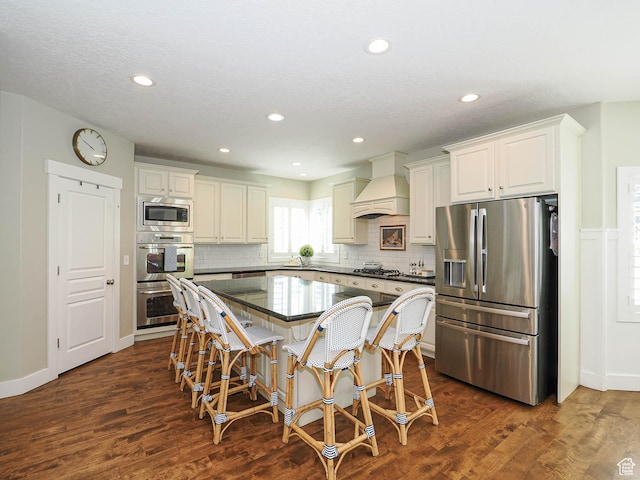 618 E Beaumont Way S, Draper, UT 84020 - kitchen with appliances with stainless steel finishes, premium range hood, a kitchen breakfast bar, a kitchen island, and tasteful backsplash