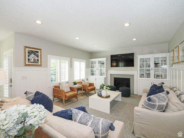 618 E Beaumont Way S, Draper, UT 84020 - living area with a decorative wall, a wainscoted wall, recessed lighting, and a glass covered fireplace