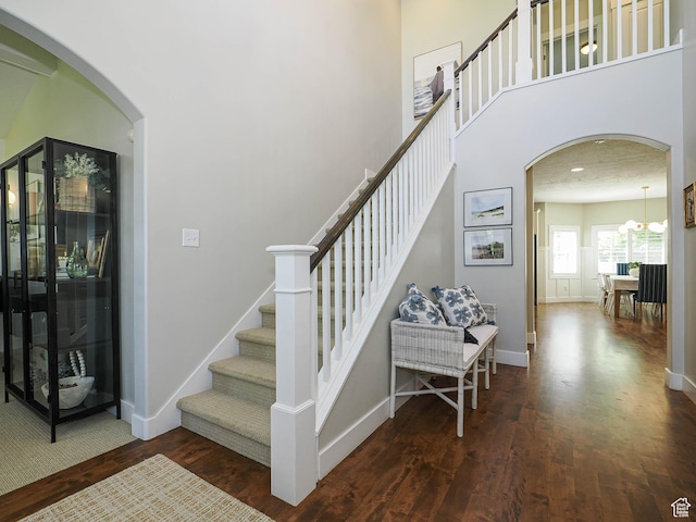 618 E Beaumont Way S, Draper, UT 84020 - staircase with wood finished floors, arched walkways, a high ceiling, and a chandelier