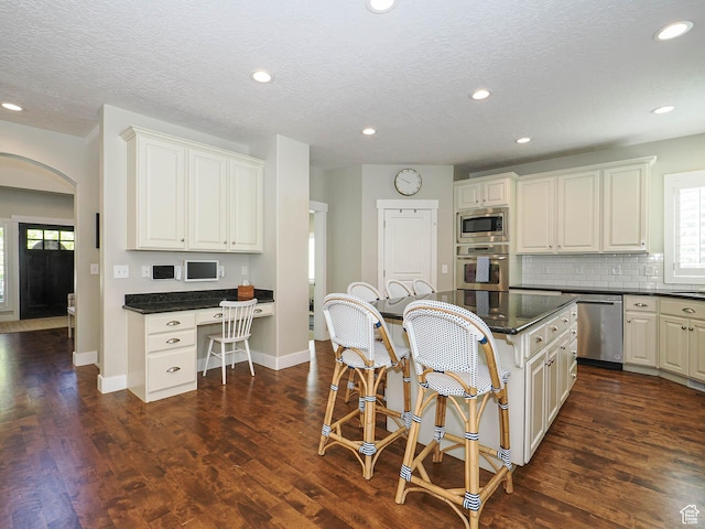 618 E Beaumont Way S, Draper, UT 84020 - kitchen with stainless steel appliances, arched walkways, a kitchen breakfast bar, healthy amount of natural light, and recessed lighting