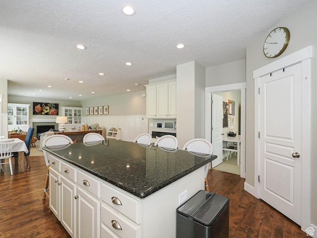 618 E Beaumont Way S, Draper, UT 84020 - kitchen featuring a kitchen island, a textured ceiling, recessed lighting, dark wood-style floors, and a fireplace