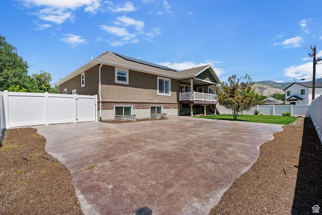 809 W 1320 N, West Bountiful, UT 84087 - rear view of property featuring roof mounted solar panels, a fenced backyard, a patio, stucco siding, and a gate