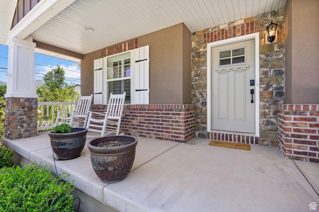 809 W 1320 N, West Bountiful, UT 84087 - view of exterior entry with a porch, stone siding, stucco siding, and brick siding