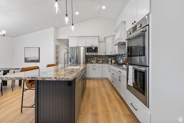 809 W 1320 N, West Bountiful, UT 84087 - kitchen with appliances with stainless steel finishes, tasteful backsplash, light stone counters, a breakfast bar area, and vaulted ceiling