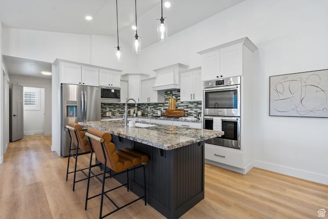 809 W 1320 N, West Bountiful, UT 84087 - kitchen featuring stainless steel appliances, stone countertops, backsplash, a breakfast bar area, and a center island with sink