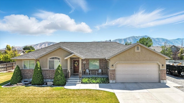 758 N 400 E, Tremonton, UT 84337 - view of front of house with brick siding, stucco siding, an attached garage, driveway, and a mountain view