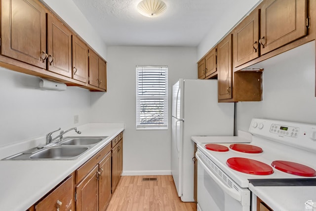 1030 Healy St Unit 2, Ogden, UT 84403 - kitchen featuring white appliances, brown cabinets, light wood finished floors, and light countertops
